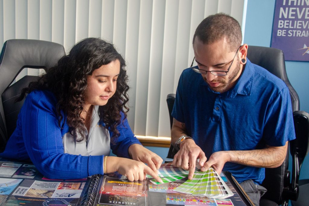 Mailstar designers comparing Pantone color swatches over a design portfolio